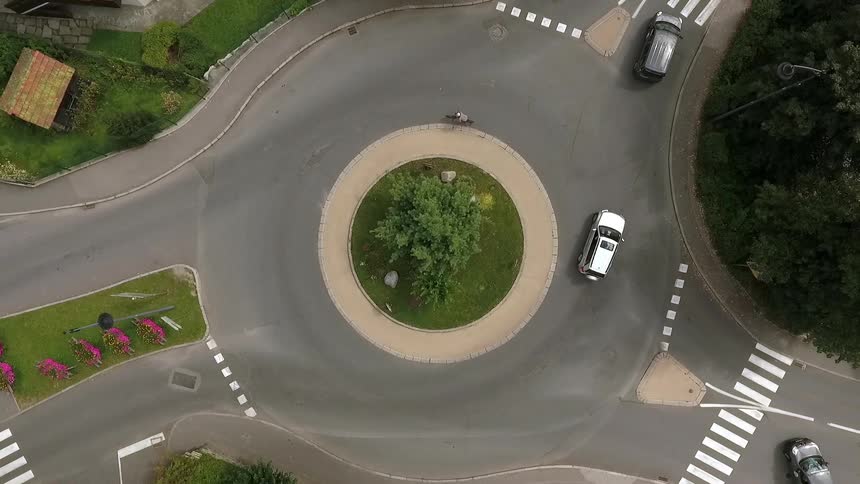 Cars and bikes enter and travel around a runaround intersection