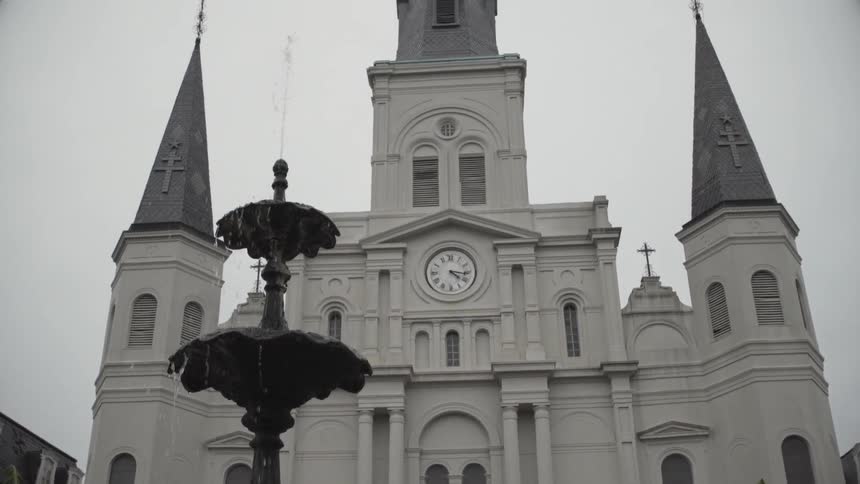 A building has a fountain and clock on the front