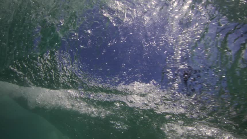 View from underwater of a boat splashing as it moves overhead