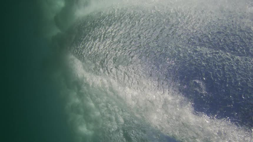A surfer catching a wave at sea during the day