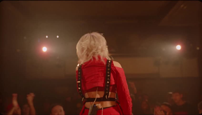 View of a woman with her back turned performing on a nightclub stage