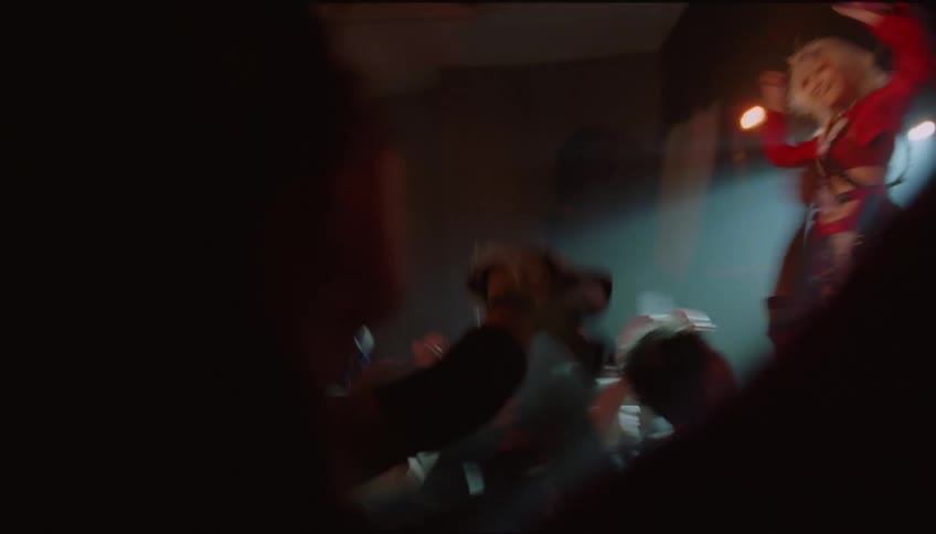 Happy woman dancing and cheering in the crowd at a concert near the stage