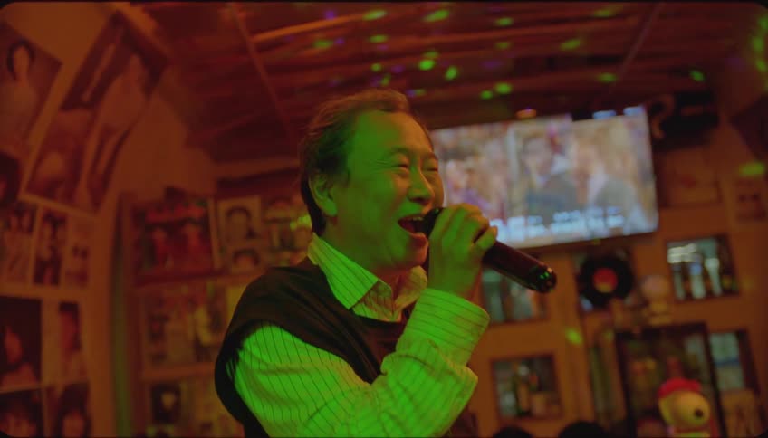 Asian man sinks karaoke at a party