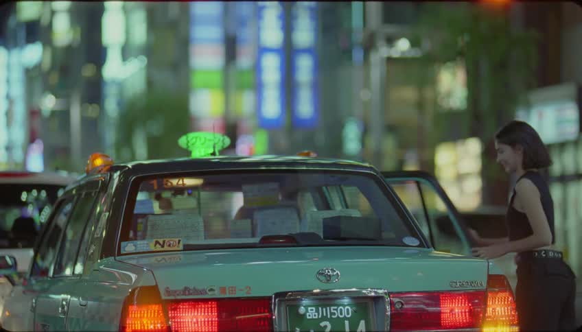 A woman gets out of a light blue taxi