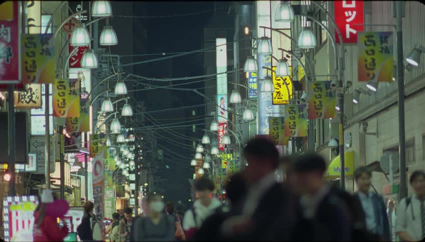 People walking on a illuminated commercial street at night