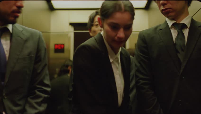 A woman moves past men to get off the elevator