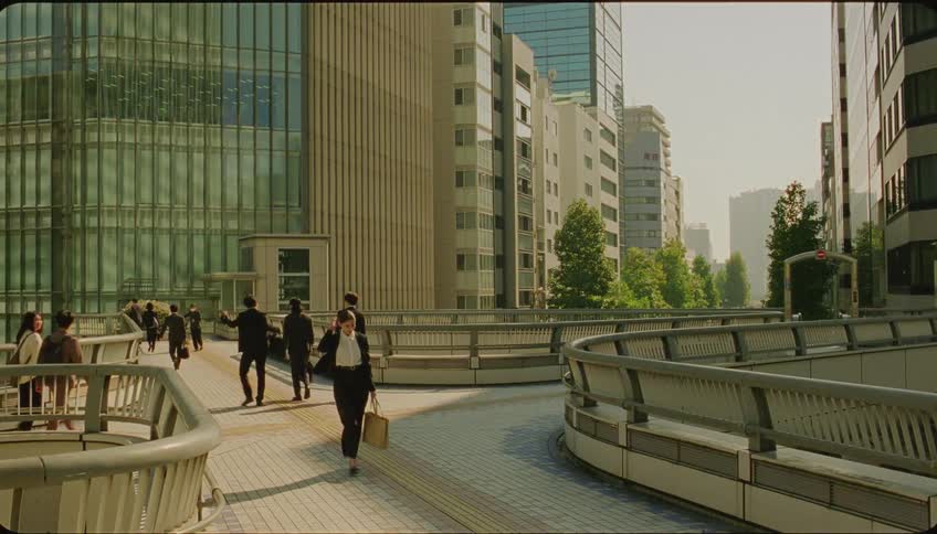 Professional coworkers part with bows on pedestrian walkway near skyscrapers