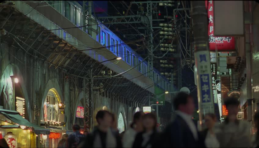 Elevated transit line over the city streets at night