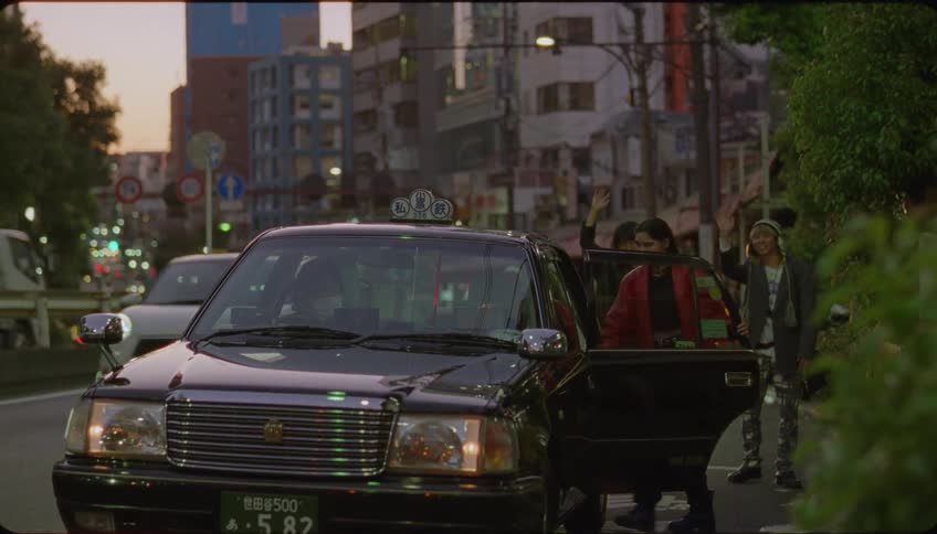 Friends hug and say goodbye to a girl boarding a cab in the city