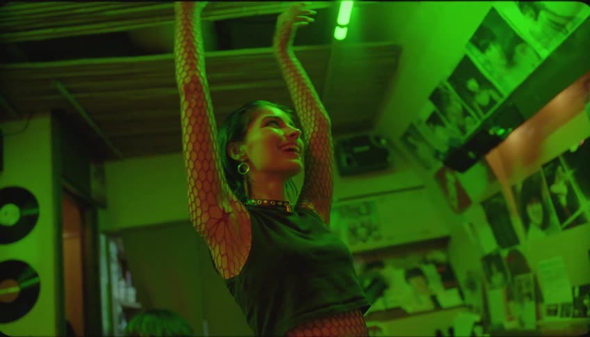 Woman with arms raised dancing happily in a pub