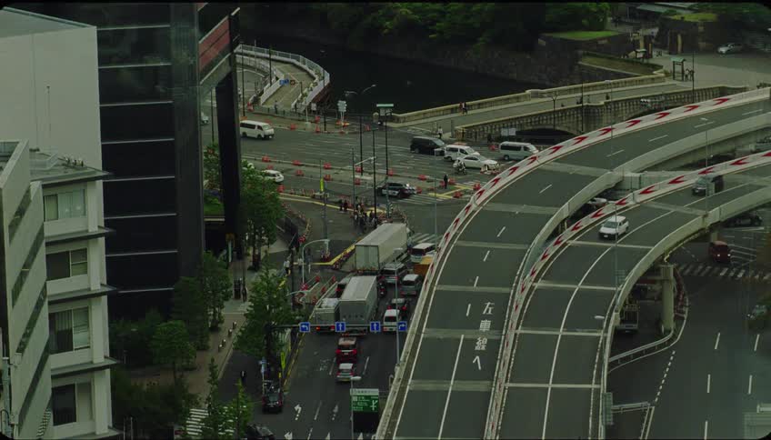 Traffic and pedestrians move along roads near river
