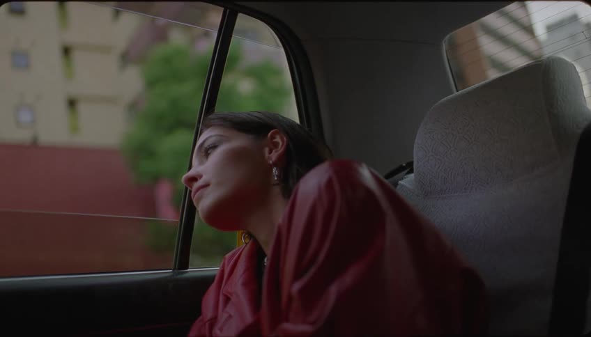 A woman admiring the city through the window of a vehicle