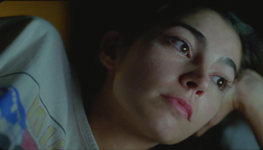 Woman wearing a white t shirt watches television