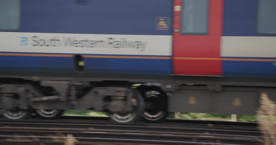 Passenger train passes sign welcoming arrivals to a junction