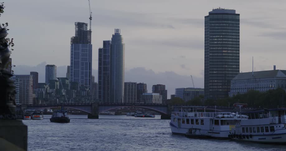 Ferryboats sit docked across bridge from city downtown on an overcast day