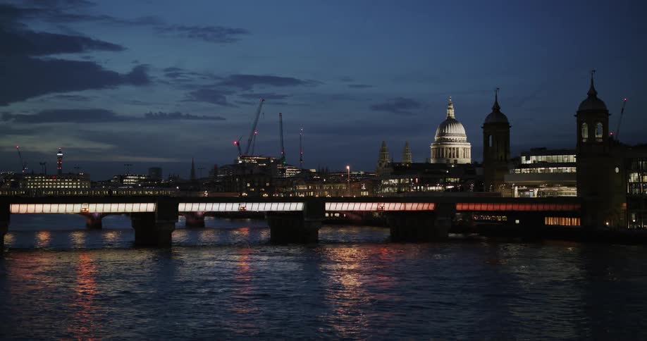 Panorama of a bridge over the sea with a train passing at night in a metropolis