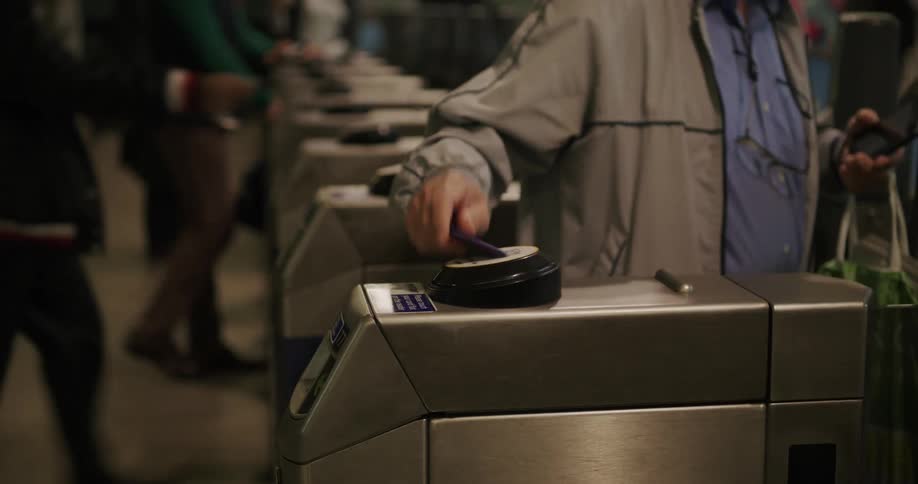 People scan their cell phones on the turnstiles