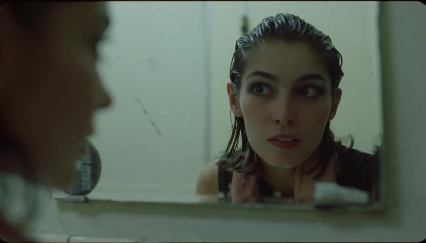 A lady talking while checking her hair inside a washroom