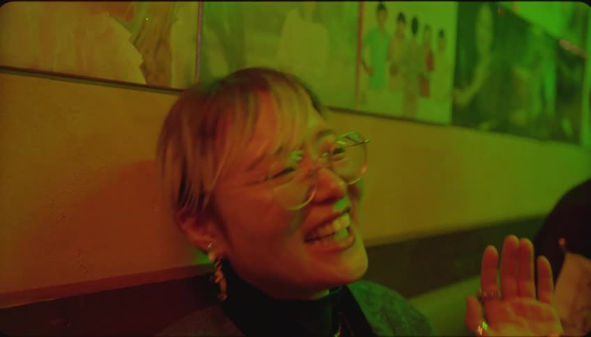 A woman is playing the tambourine and smiling