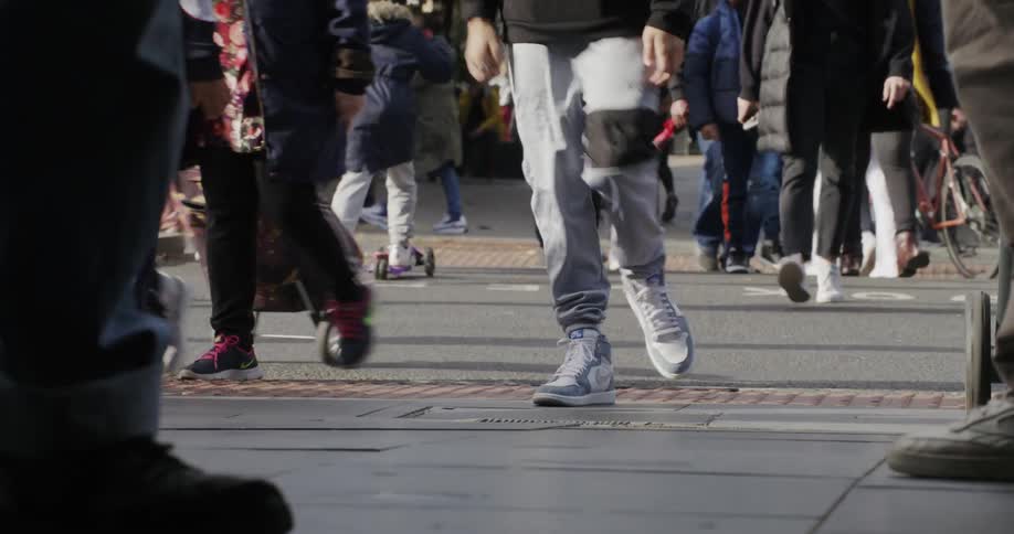 Closeup of peoples legs walking on city sidewalks