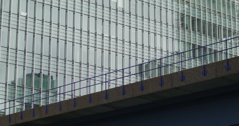 Birds fly over bridge near skyscraper with reflective surface