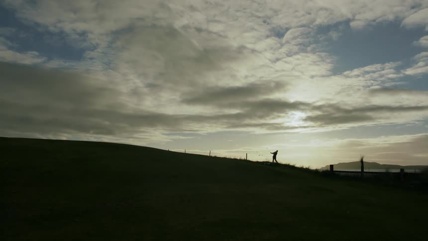 A man is standing in the distance on the dark field