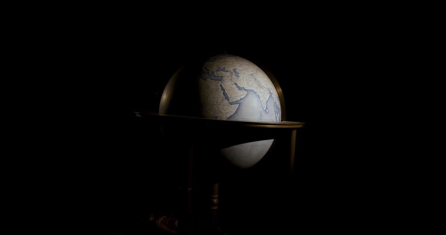 Light shines on a globe as it floats and turns as it spins in its stand