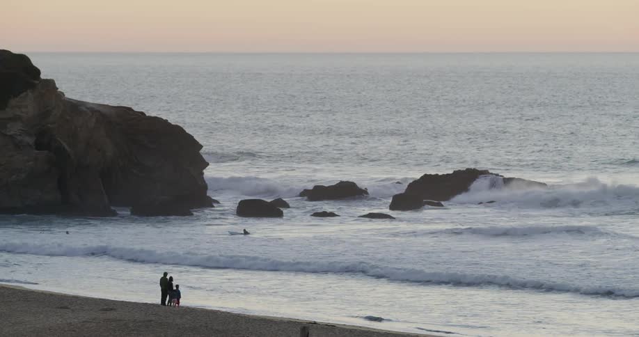 A family are standing on the beach