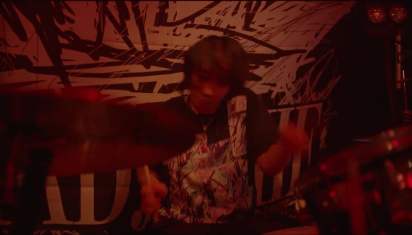 A drummer quickly beating the drums in a night club