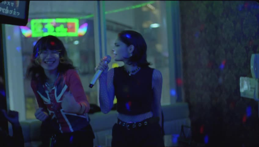 Group of friends sing karaoke at a party