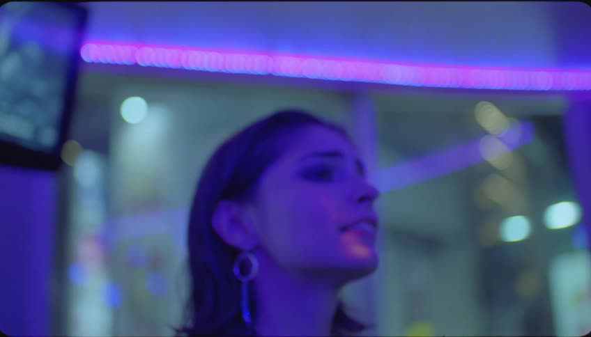 A woman holds a karaoke microphone while singing as friends watch