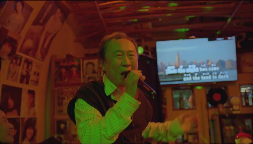 A man sing in a pub and people seated claps while listening