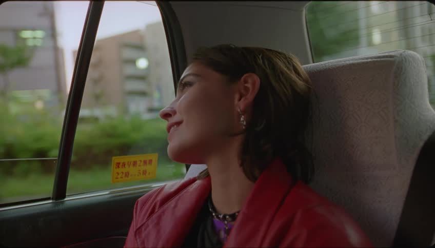 Portrait of a woman inside a taxi waving goodbye to her family and feeling happy