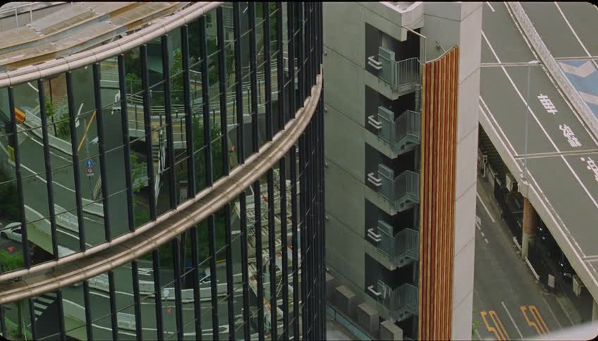 Cars driving on the highway reflect on a building facade