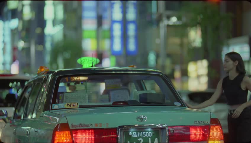 A woman gets out of a light blue taxi