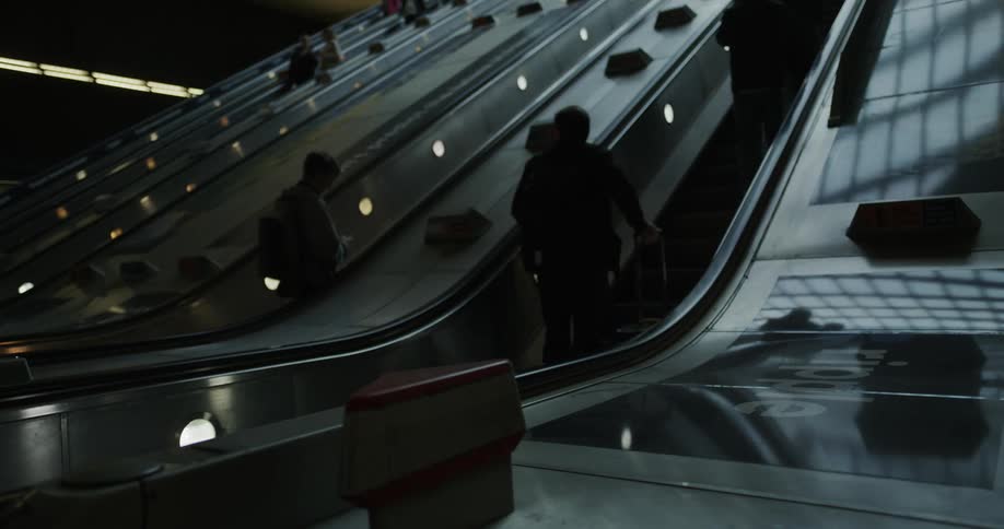 People going up and down on escalators in an indoor environment
