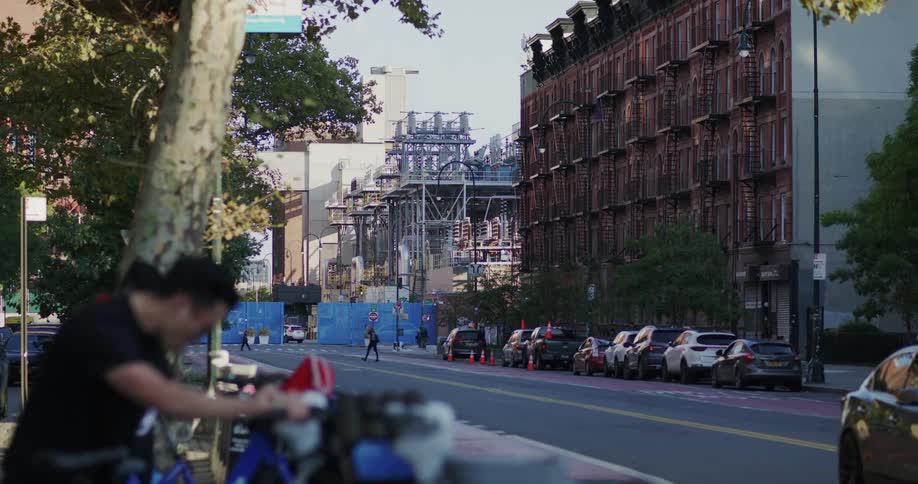 Panorama of a street in a metropolis with cars passing people walking and parking bikes