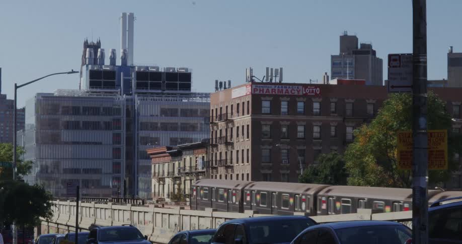 View of buildings in a metropolis with a train passing on an overpass on a cloudless day