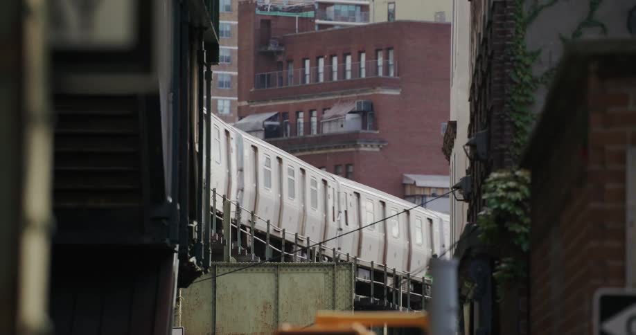 A train passing on the tracks near a city building