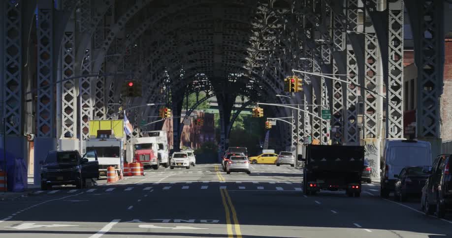 Cars driving on a road under a bridge in the city