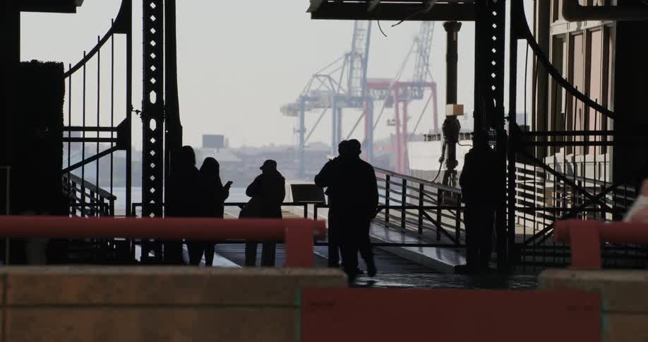 People waiting at a port in daylight