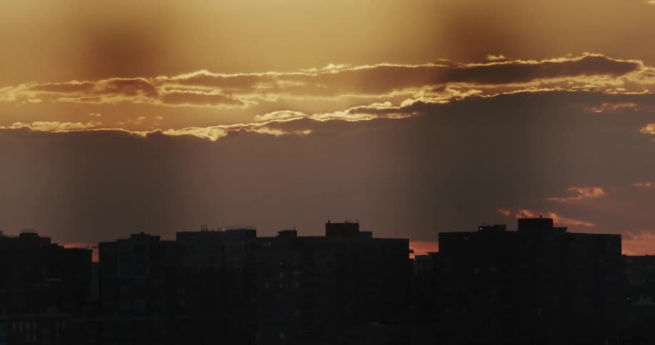 Airplane flying over the city skyline at sunset