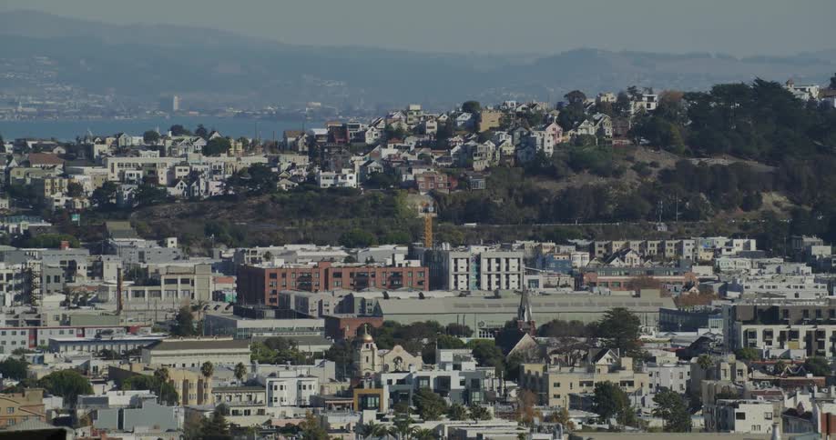 Cars drive on a road through the hills in the city