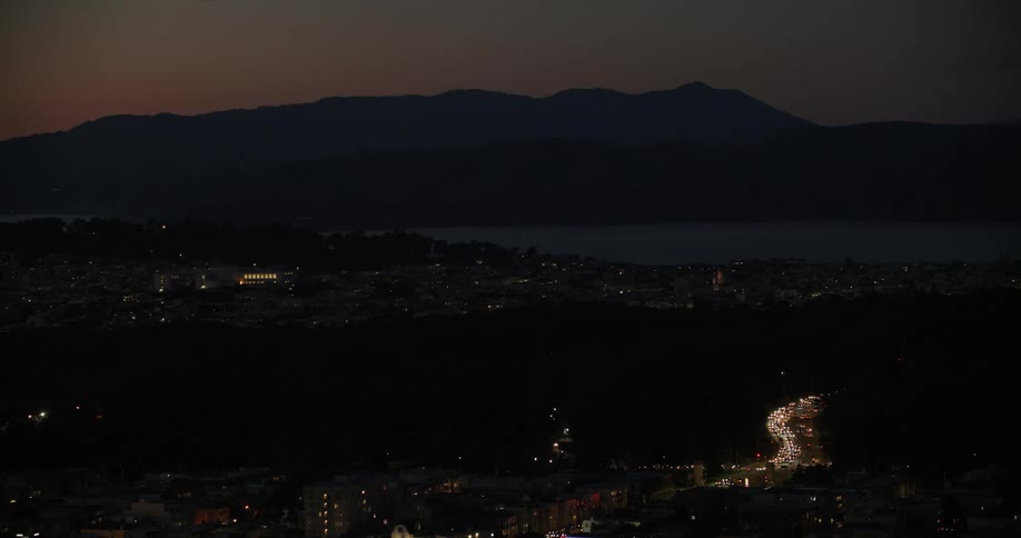 Aerial view of a city at night with a mountain range in the background