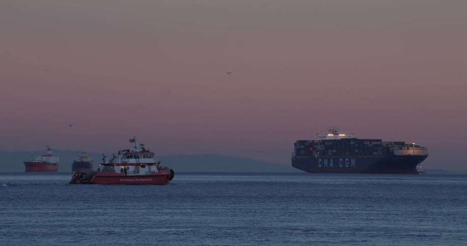 A small boat heading towards another larger boat that is stopped in the water