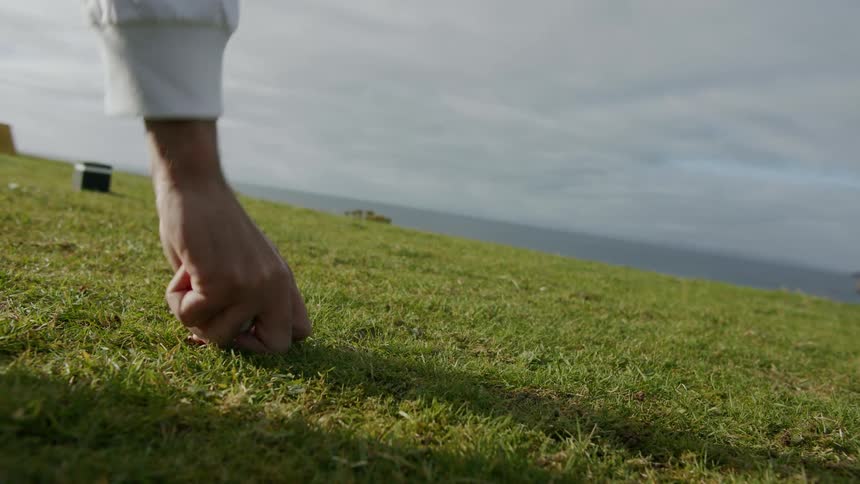 Man placing a golf ball on a tee in the golf course