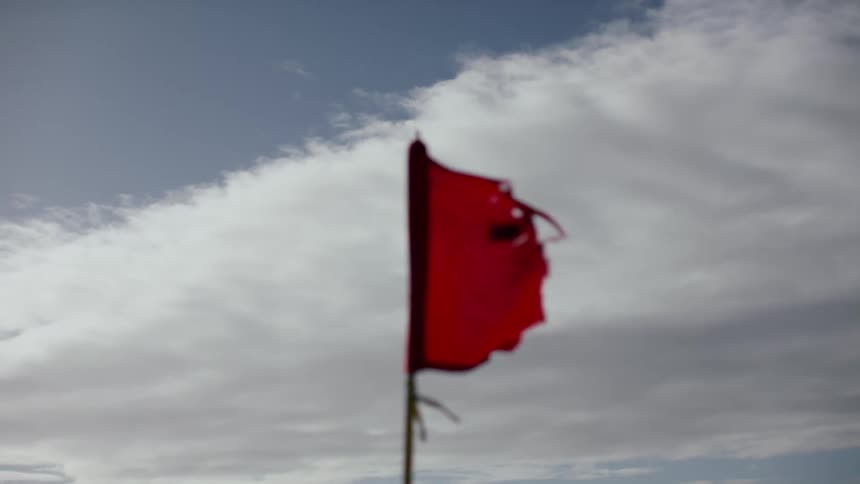 Closeup of a red flag in motion moved by the force of the wind