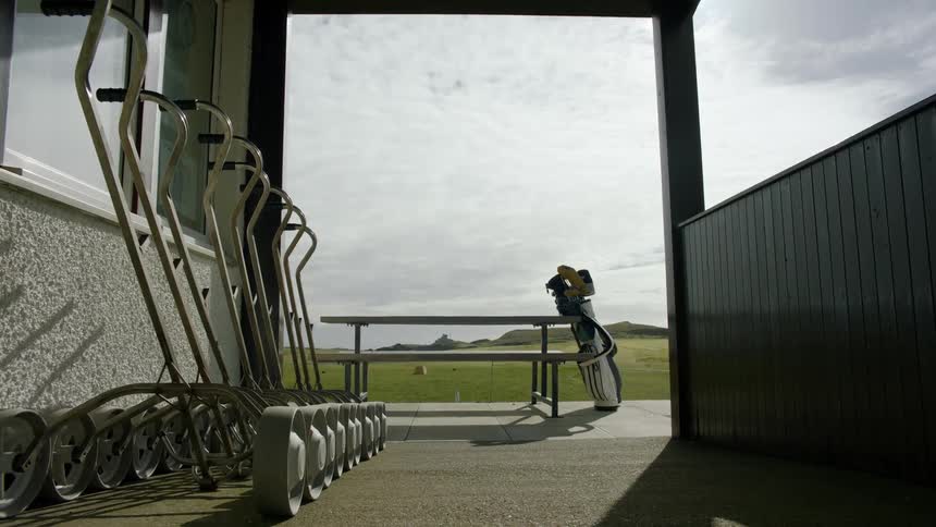 View of golf equipment in a tent facing the field and the sea