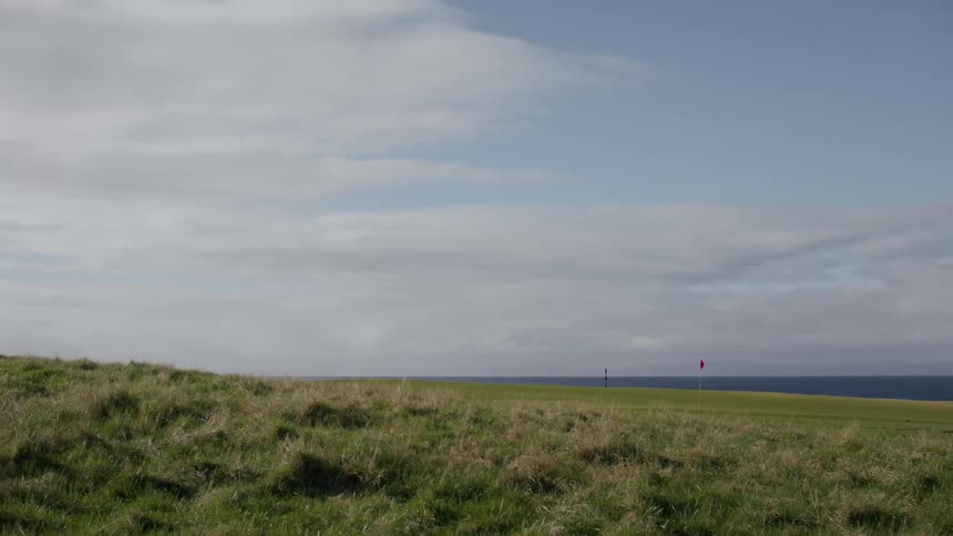 A huge lawn on a golf course close to the sea