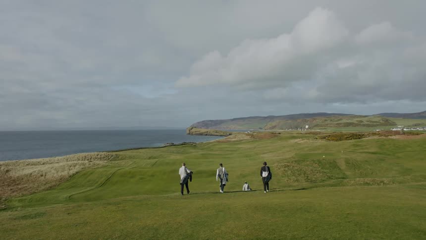 People walk on the golf course with their bags